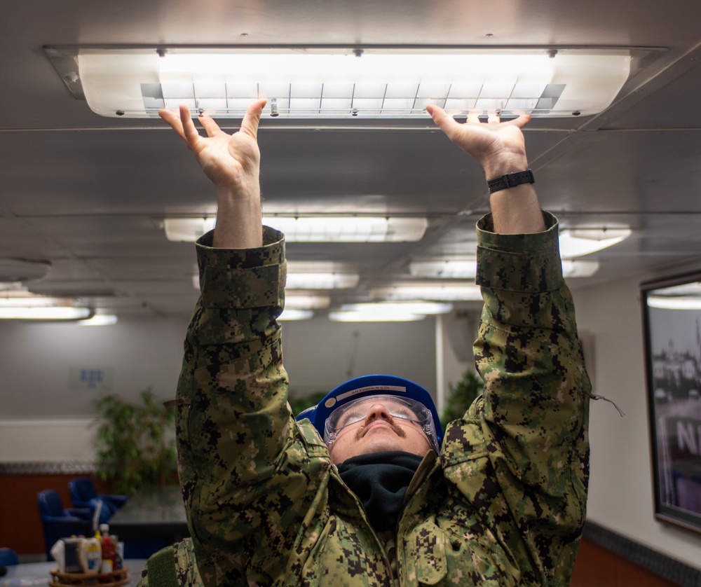 USS Ronald Reagan (CVN 76) Sailors conduct light fixture maintenance