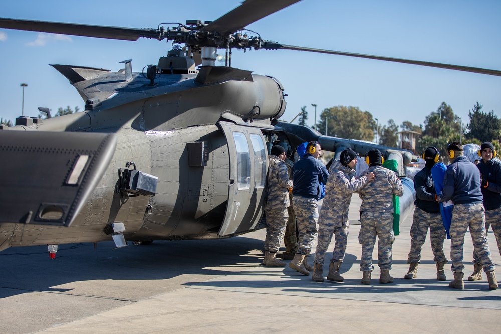 A US Army UH-60 Blackhawk is loaded with humanitarian aid supplies