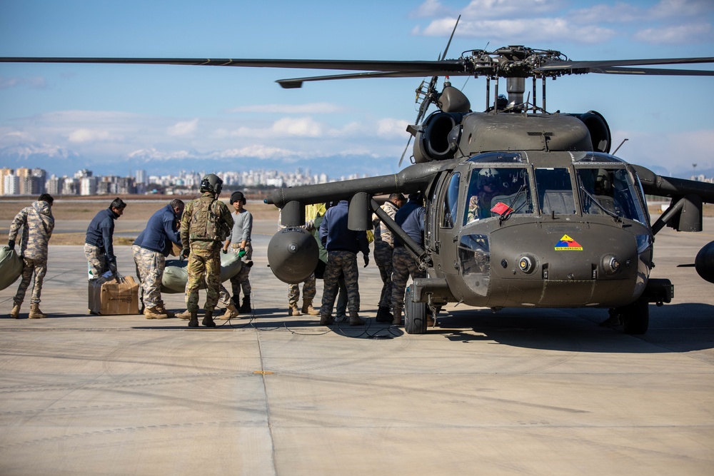 A US Army UH-60 Blackhawk is loaded with humanitarian aid supplies