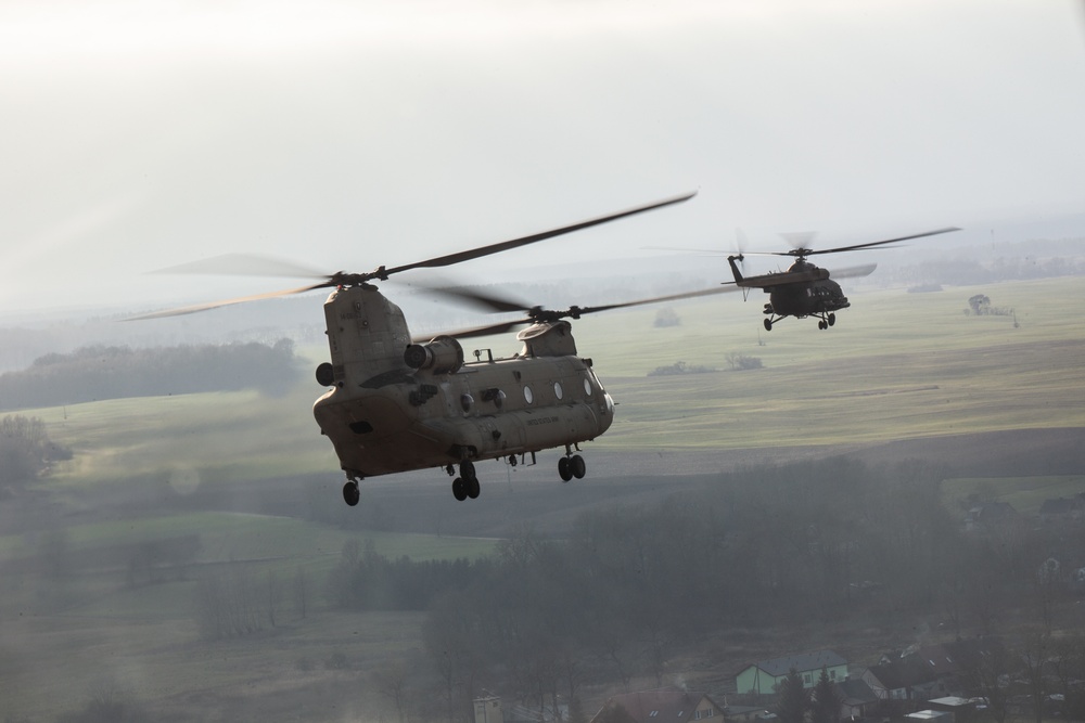 A U.S. CH-47 Chinook and a Polish MI-17 helicopter fly together during Rotor 23'