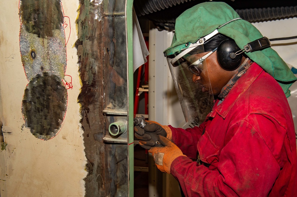 Contractor grinds metal aboard the USS John C. Stennis