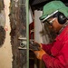 Contractor grinds metal aboard the USS John C. Stennis