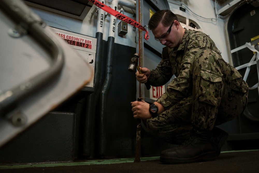 USS Carl Vinson (CVN70) Sailor perform deck maintenance