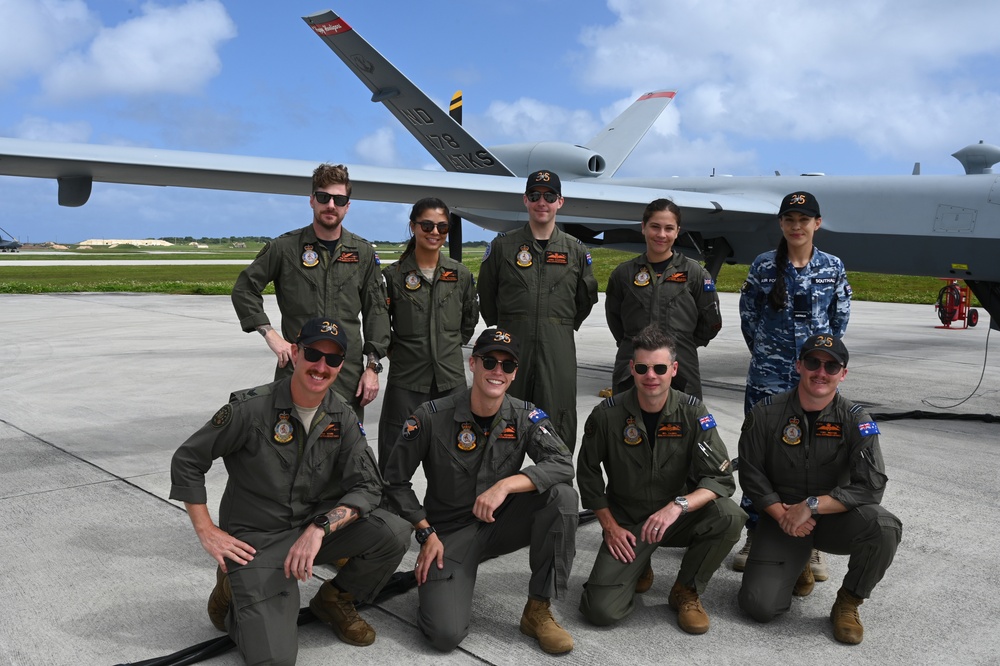 RAAF members pose for a photos with USAF MQ-9 Reaper