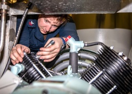 HT1 Jacob Williams installs a hydraulic pump aboard USS Charleston