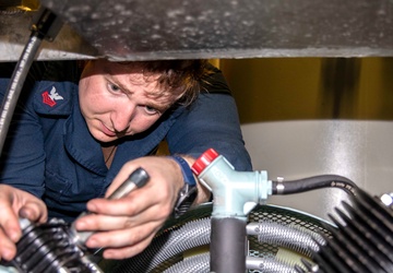 HT1 Jacob Williams installs a hydraulic pump aboard USS Charleston