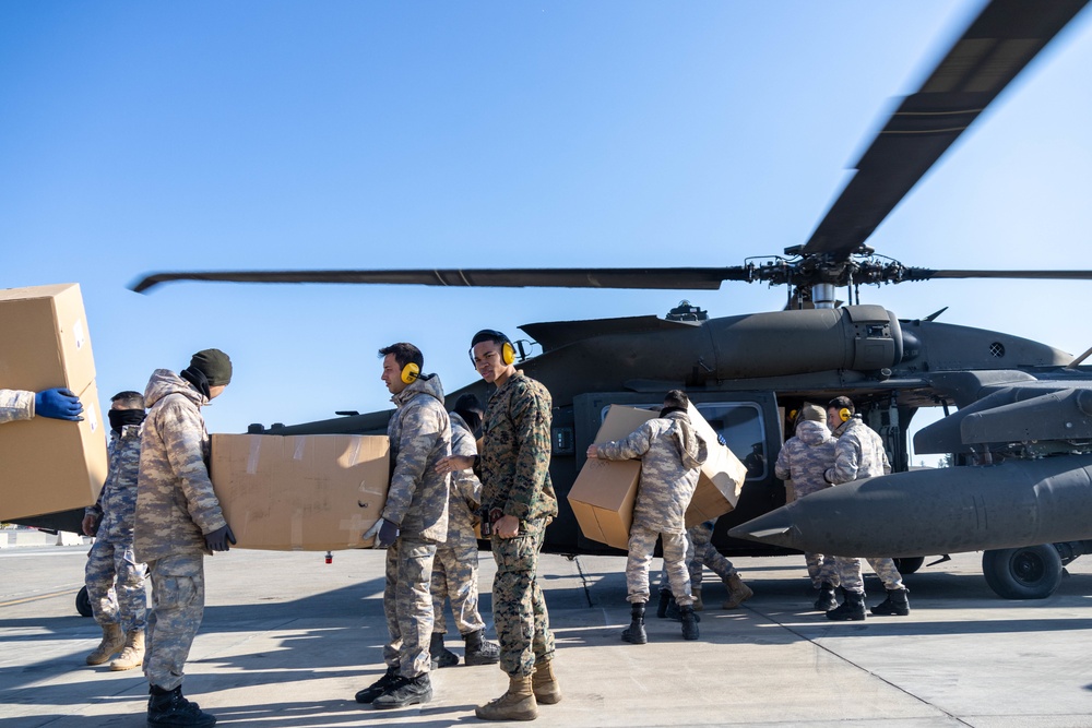 A US Army UH-60 Blackhawk is loaded with humanitarian aid supplies
