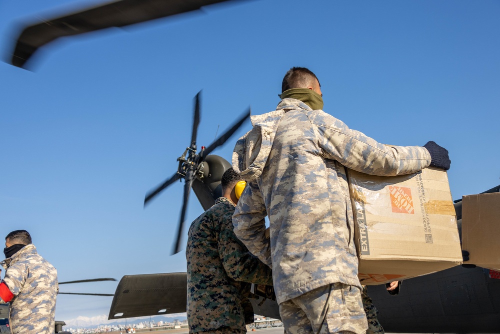 A US Army UH-60 Blackhawk is loaded with humanitarian aid supplies