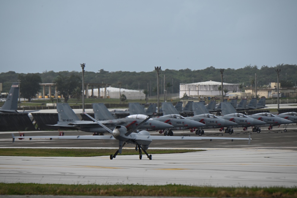 MQ-9 Reaper taxis past a Japanese Air-Self Defense Mitsubishi F-15J