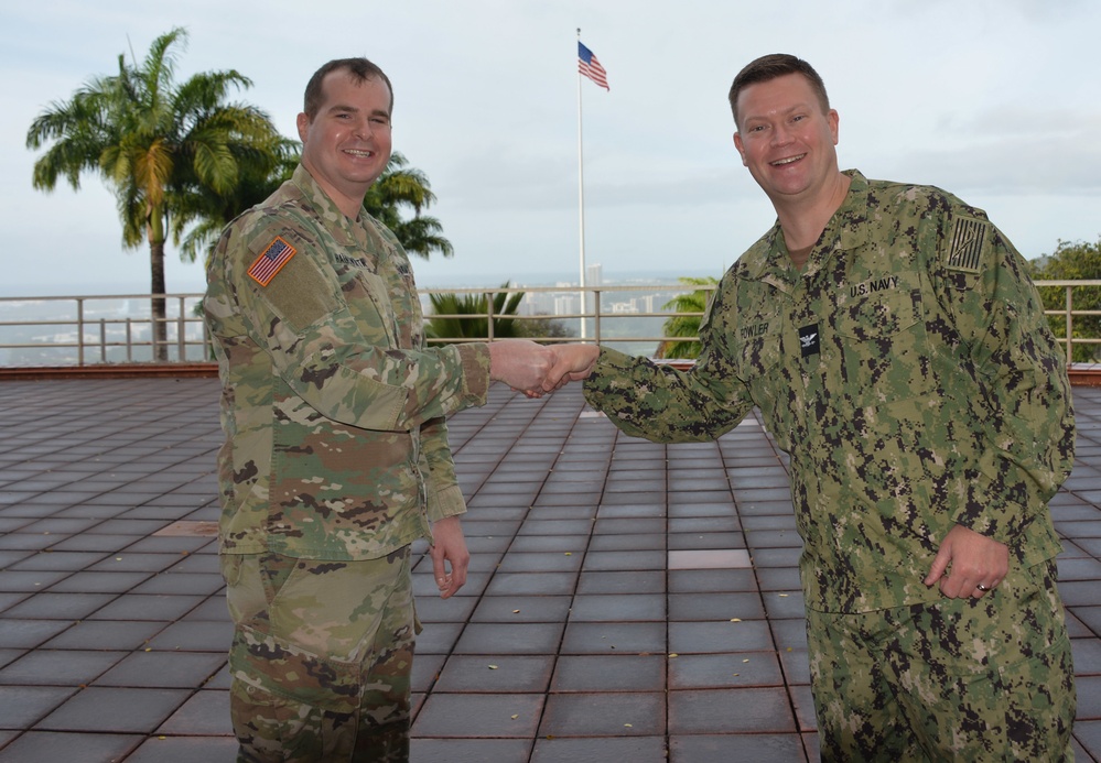 Maj. Jeffrey Hainsworth receives DCO coin from Navy Capt. Ian Fowler