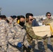 U.S. Army Soldier helps load CH-47F Chinook with humanitarian aid supplies