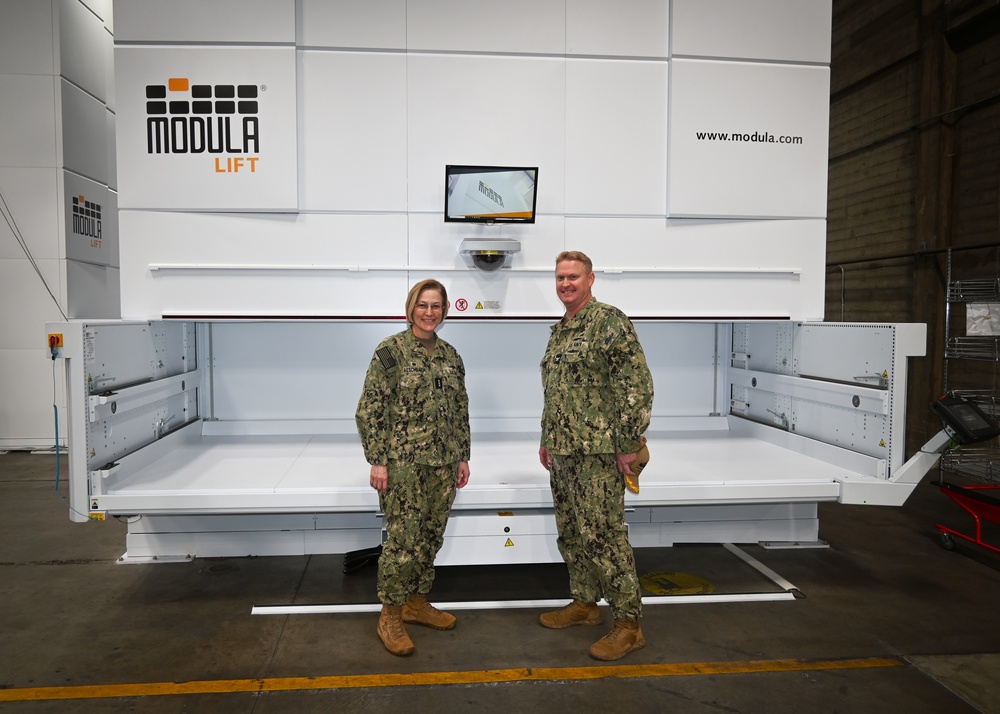 Vice Adm. Kelly Aeschbach, Commander, NIF, stands beside Capt. Cory Schemm, commanding officer, NAVSP Fleet Logistics Center San Diego, showcasing one of the new Modula Vertical Lift Modules at the 5G smart warehouse on NAS - North Island, Feb.15.