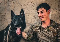 Army Explosive Ordnance Disposal officer bonds with Navy working dog on battlefield