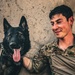 Army Explosive Ordnance Disposal officer bonds with Navy working dog on battlefield