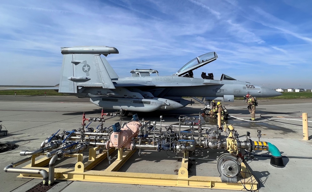 Firefighters from Naval Air Station Lemoore monitor a recently extinguished fire on an EA-18G.