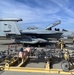 Firefighters from Naval Air Station Lemoore monitor a recently extinguished fire on an EA-18G.