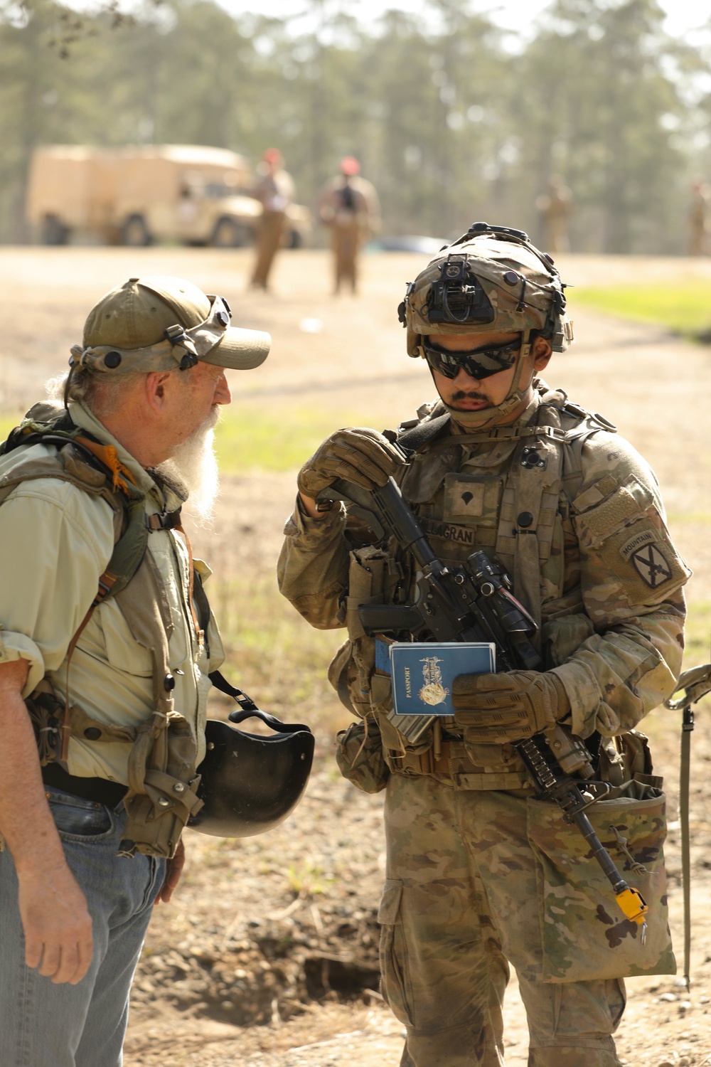 Soldiers with 2BCT of the 10th Mountain Division interact with role players serving as internally displaced people as part of the JRTC