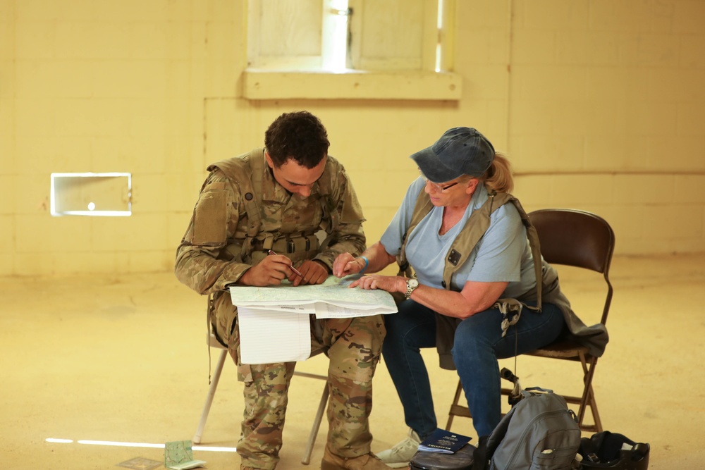 Soldiers with 2BCT of the 10th Mountain Division interact with role players serving as internally displaced people as part of the JRTC