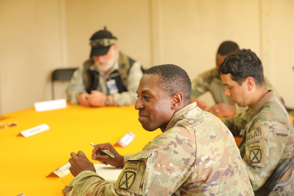 Soldiers with 2BCT of the 10th Mountain Division interact with role players serving as internally displaced people as part of the JRTC