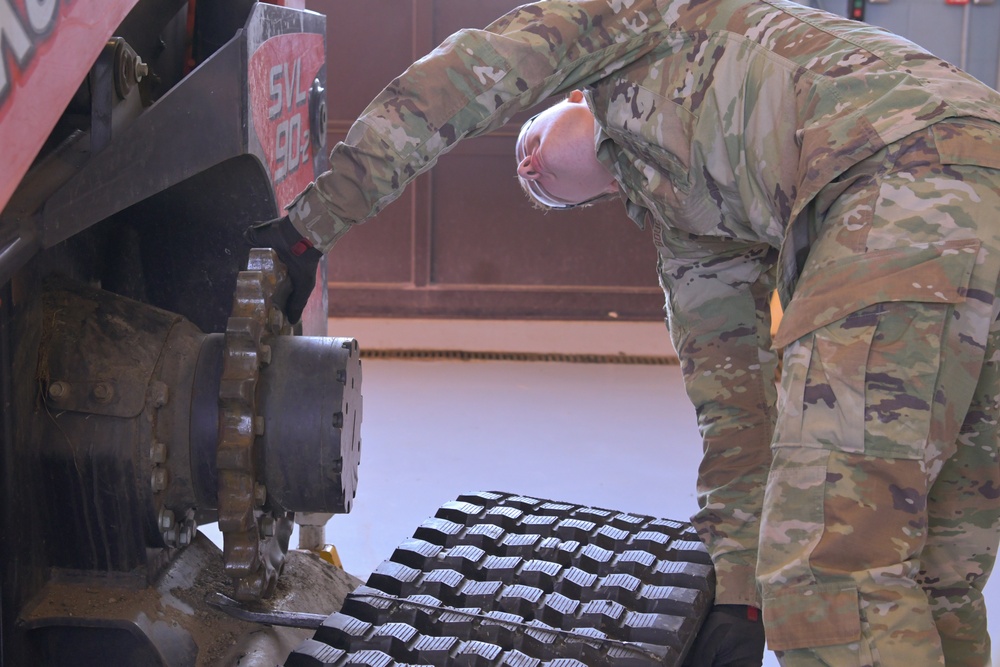 Airman Skyler Boucher changes a track on a compact track loader