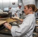 Chief Warrant Officer 2 Christine Stanley puts a citrus tuille into an oven