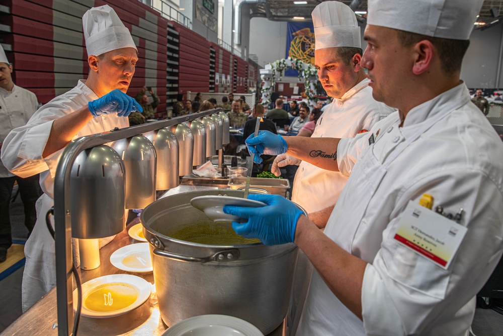 Sgt. 1st Class Jeffery Vaughan instructs Sgt. Jacob Hernandez and Sgt. Steven Philipps on serving their soup