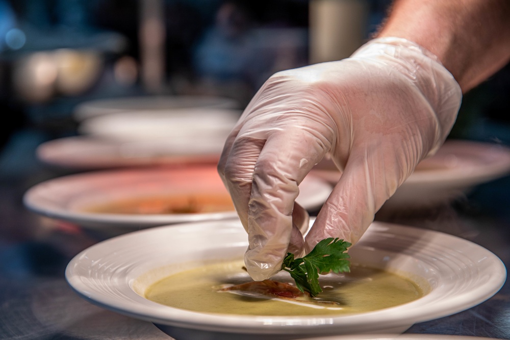 A Soldier puts the finishing touches on a soup