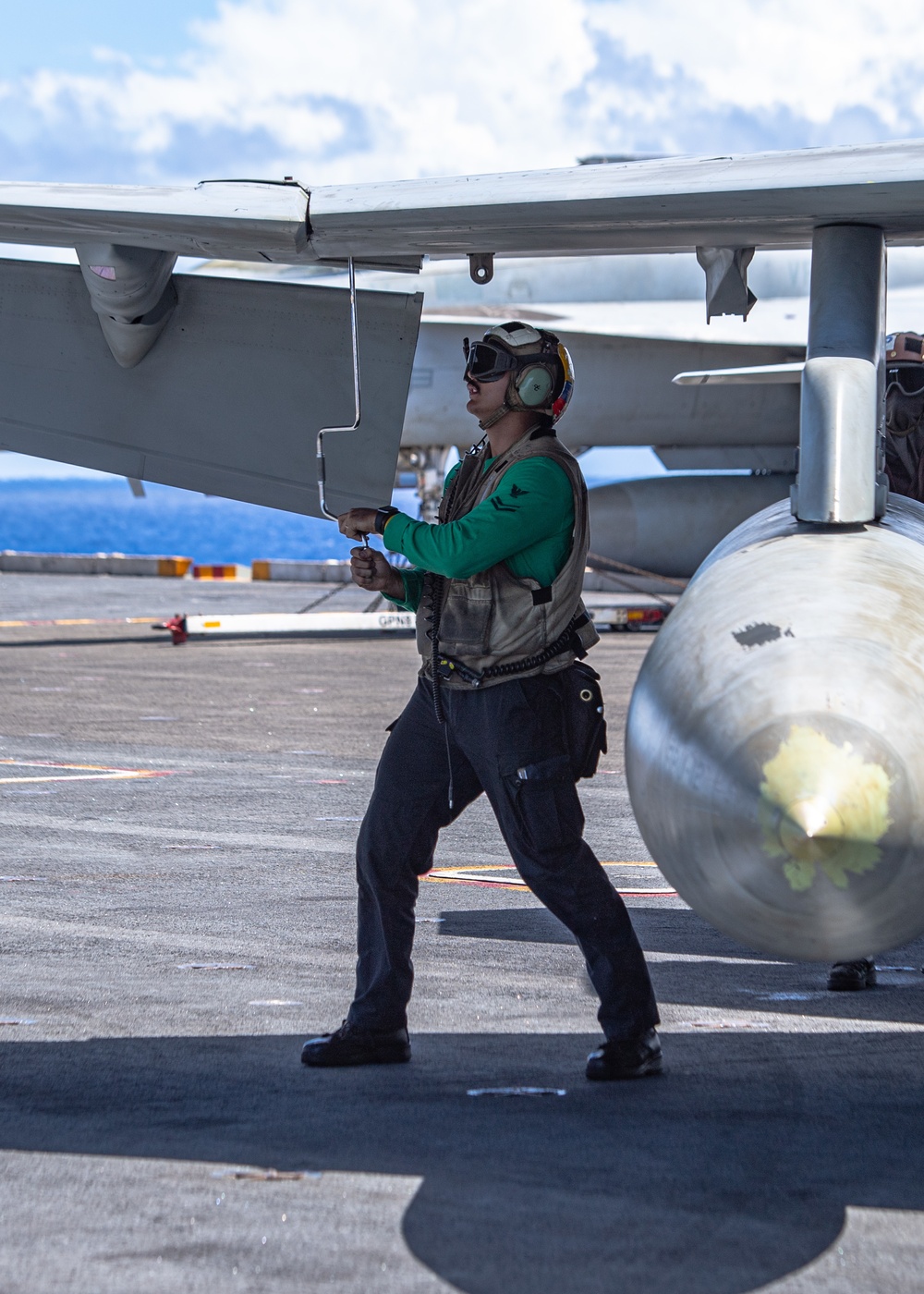 Sailor Manually Extends The Wing On An Aircraft