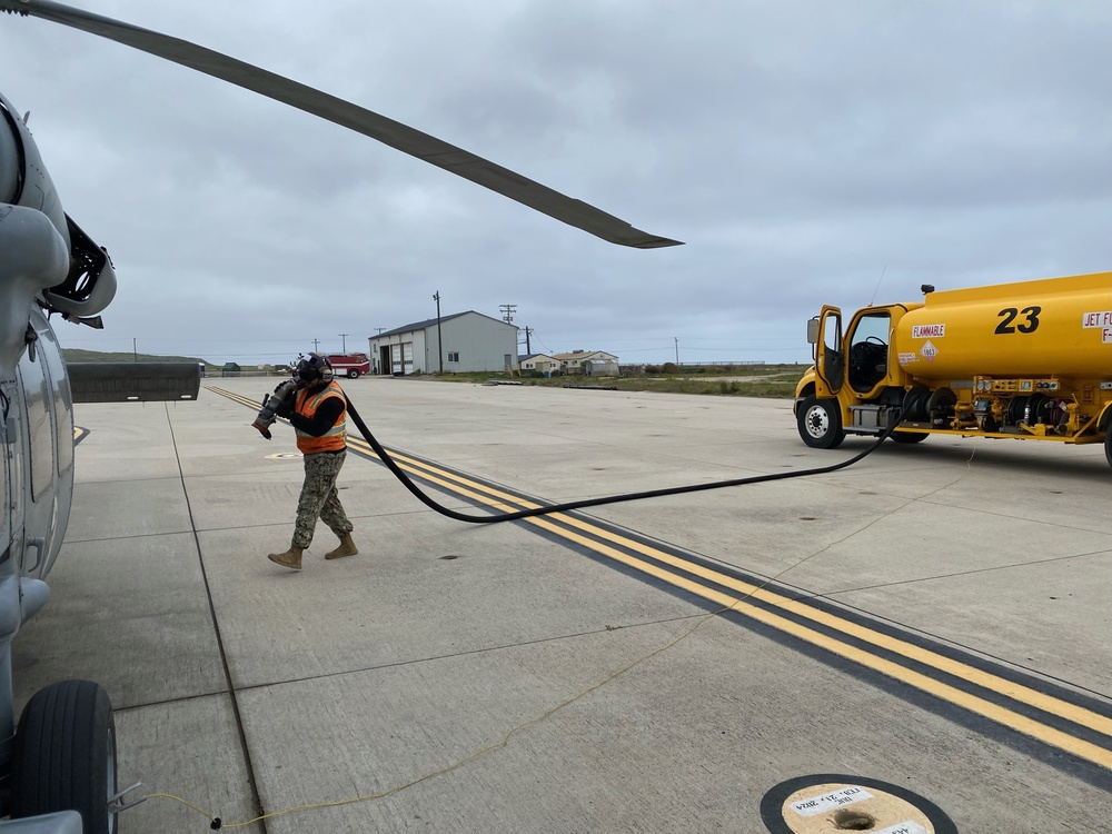 Petty Officer Third Class Luis Marcano-Schmilinsky carries the fuel hose during a routine fueling evolution on Naval Auxiliary Landing Field San Clemente Island.