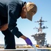 Sailor paints on the flight deck of USS Carl Vinson (CVN70)