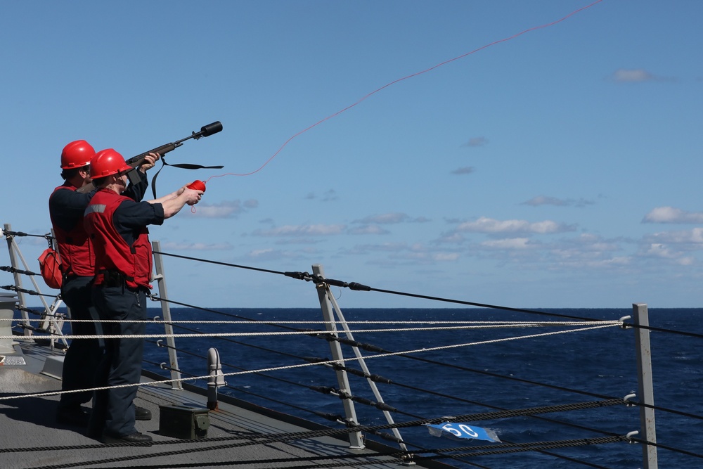 destroyer USS Thomas Hudner (DDG 116), fire a line during a replenishment at sea