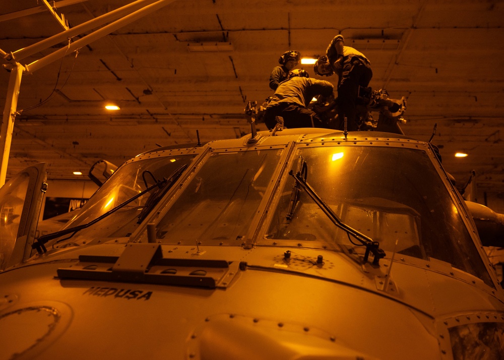 Sailors work on an MH-60S Nighthawk