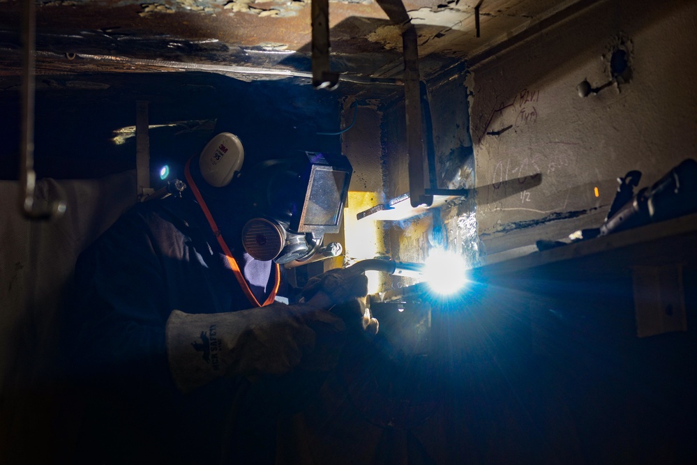 Newport News Ship yard contractor welds aboard the Nimitz-class aircraft carrier USS John C. Stennis (CVN 74)
