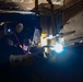 Newport News Ship yard contractor welds aboard the Nimitz-class aircraft carrier USS John C. Stennis (CVN 74)