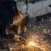 Newport News Ship yard contractor grinds down metal aboard the Nimitz-class aircraft carrier USS John C. Stennis (CVN 74)