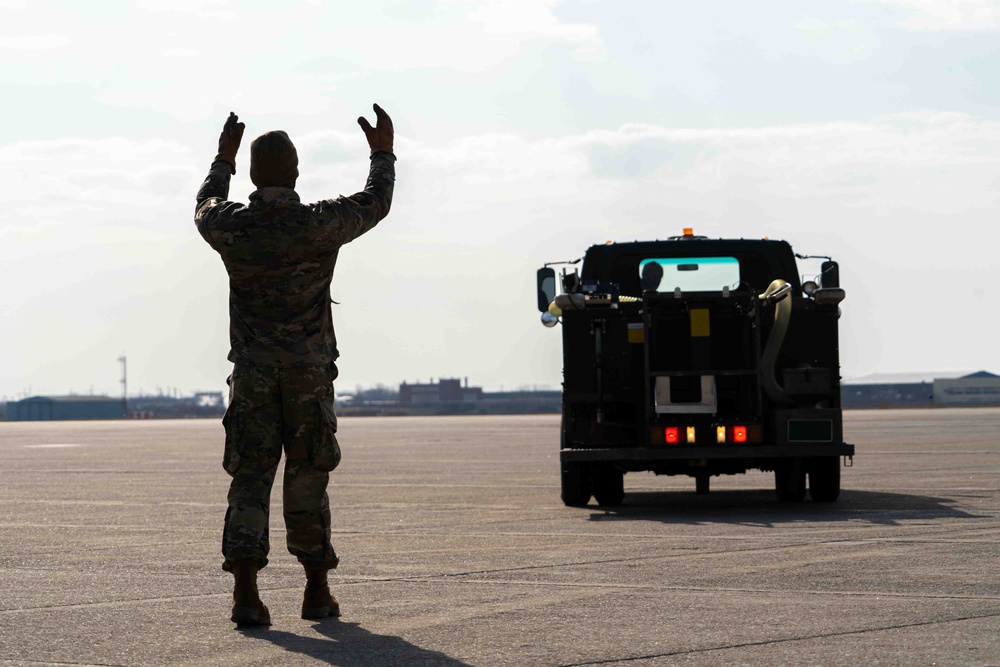 Airman at the 914th guides sewage truck towards aircraft