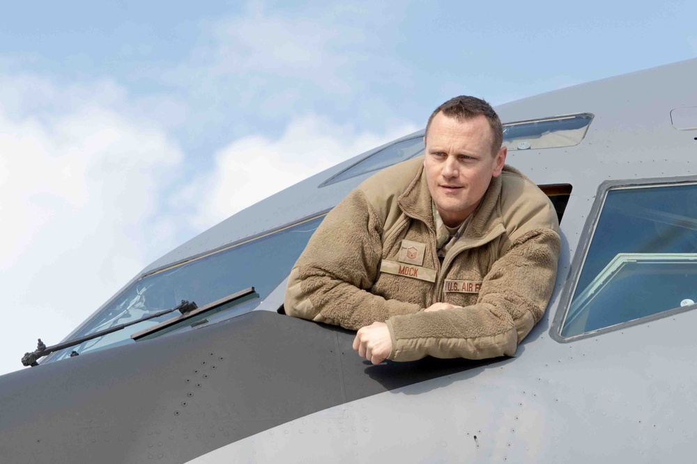 Maintainer leans out front window of KC-135 during pre-flight inspection