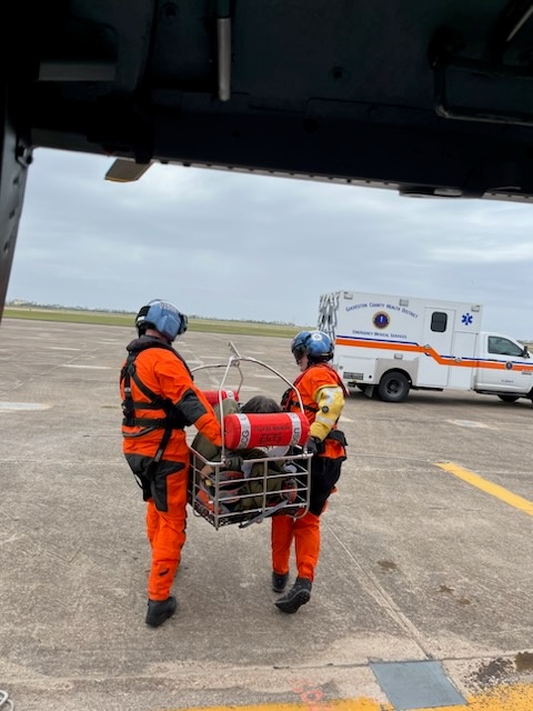 A Coast Guard Air Station Houston MH-65 Dolphin helicopter crew transports a 48-year-old man to awaiting emergency medical services personnel at Scholes International Airport in Galveston, Texas, Mar. 21, 2023. The man was medevaced off the Prism Diversity, a 981-foot tanker vessel, 35 miles south of Galveston, and taken to the University of Texas Medical Branch in Galveston by EMS personnel. (U.S. Coast Guard photo courtesy, Air Station Houston)