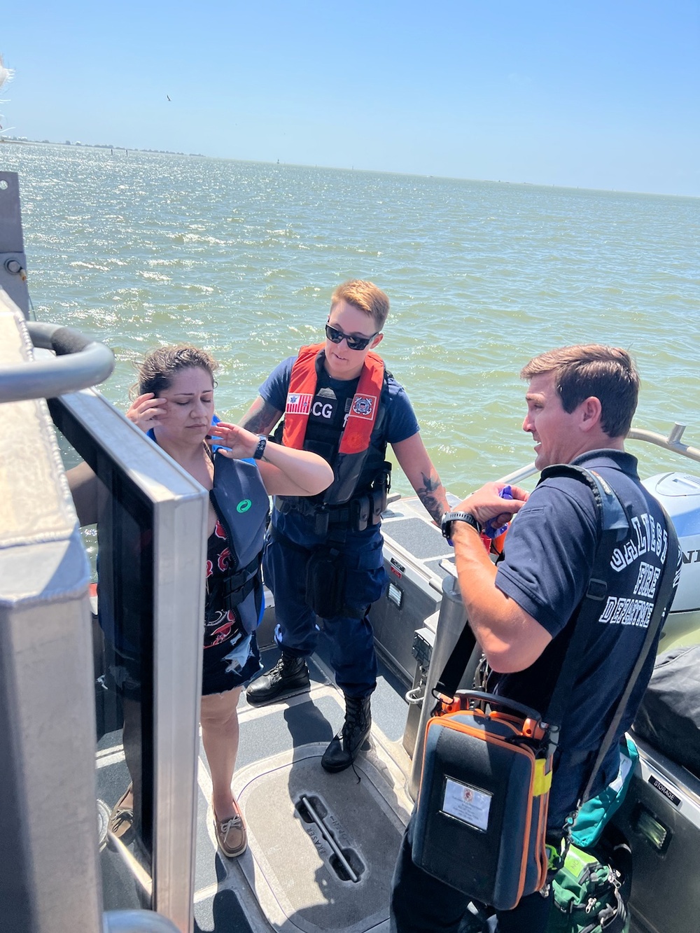 A Coast Guard Station Galveston 29-foot Response Boat–Small crewmember and a member of the Galveston Fire Department render assistance to an ailing woman near the Galveston Causeway Bridge in Galveston, Texas, March 22, 2023. The woman needed medical attention and the boat crew transferred her to emergency medical services personnel waiting at Galveston Bait and Tackle. (U.S. Coast Guard photo, courtesy Station Galveston)