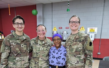28th Infantry Division Soldiers posing with a Women's Army Corps veteran at the Women's History Month celebration