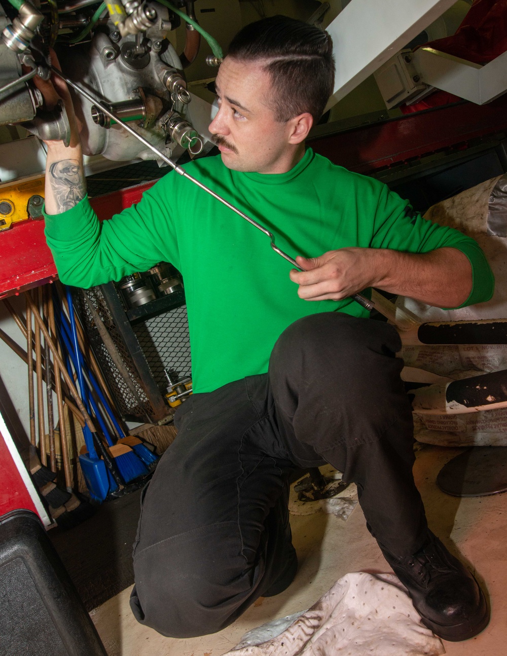 Sailor Removes Bolts From Engine