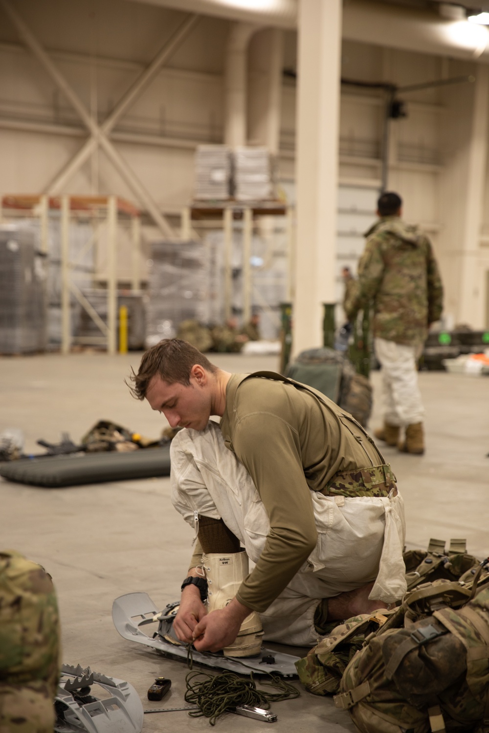 Artillery Cannon Crewmember prepares snowhoes for next movement during JPMRC