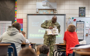 NAVAL SUPPORT ACTIVITY COMMANDER EMPHASIZES THE IMPORTANCE OF READING TO A CLASS AT PATRONIS ELEMENTARY SCHOOL