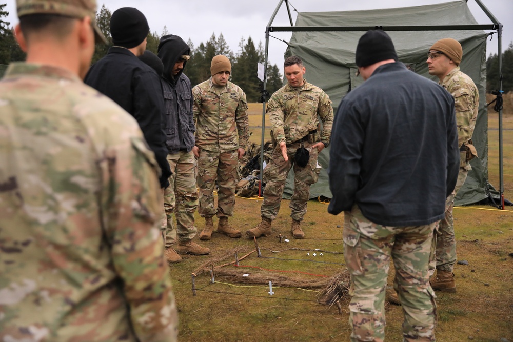 The 5th SFAB Discusses Troop Movement Using a Terrain Model During TRAP