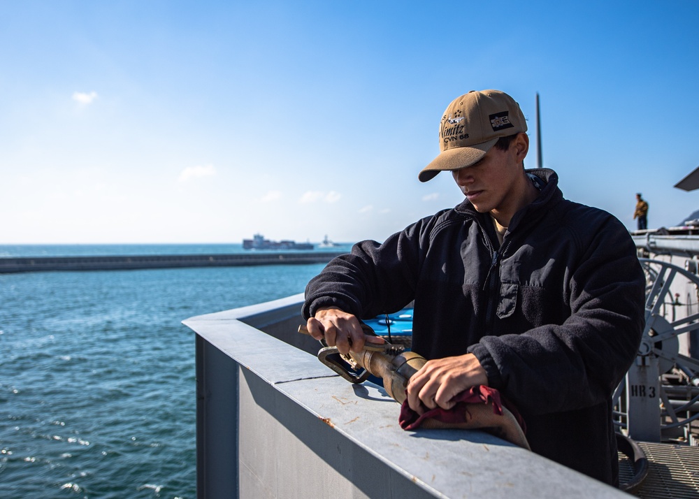 Sailor Cleans A Fire Hose