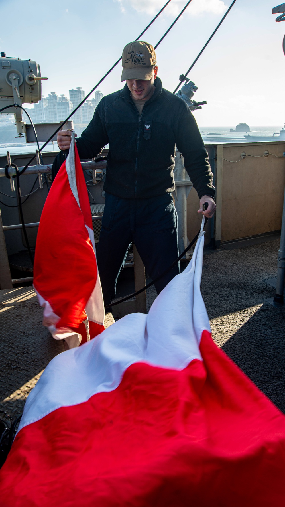 Sailor Unfurls A Signal Flag