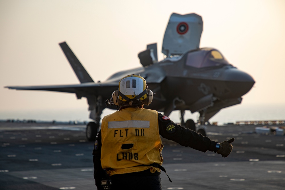 USS Makin Island flight deck operations during sunset