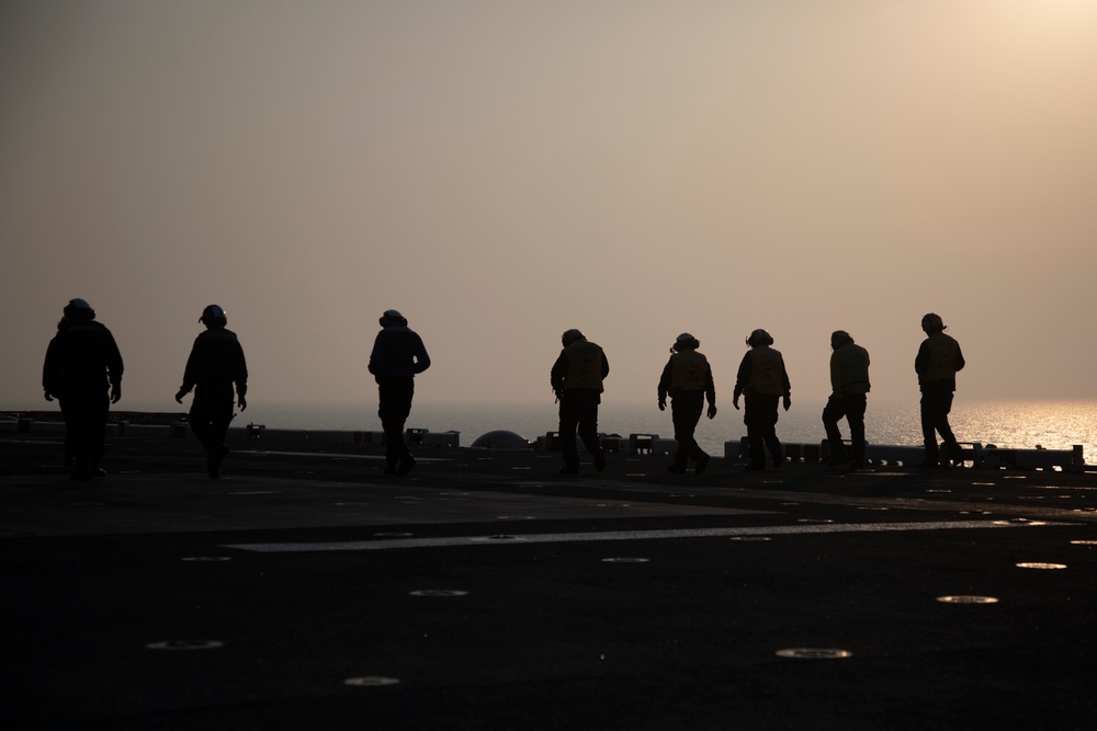 USS Makin Island flight deck operations during sunset