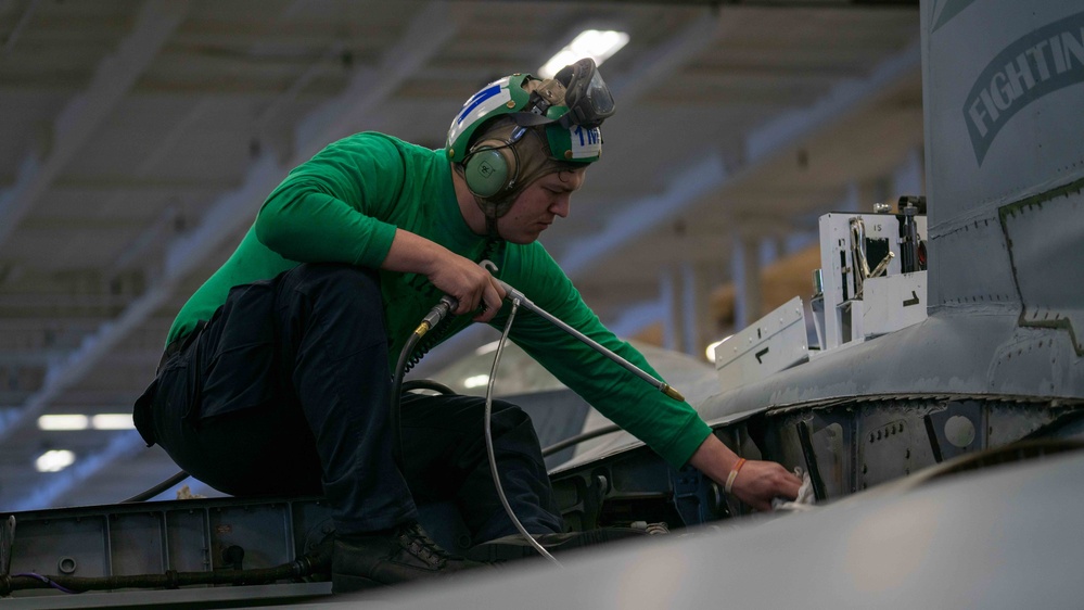 Sailor cleans jet aboard USS Carl Vinson (CVN70)