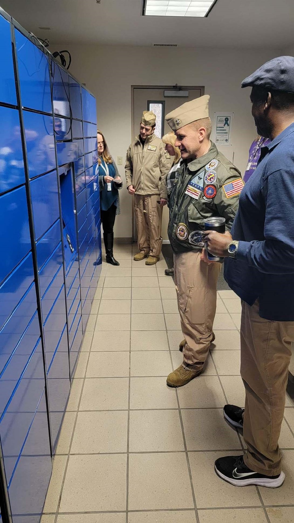 NAS Fallon Commanding Officer Capt. Shane Paul Tanner participates in a demonstration of the Intelligent Mail Locker in the NAS Fallon BEQ.